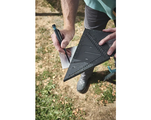 Řemeslník značí kov pomocí tesařského úhelníku a tužky.