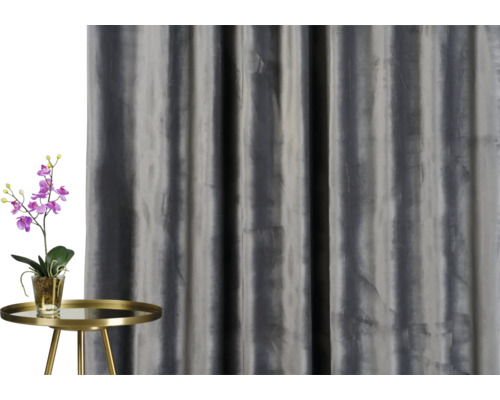 Dekorativní závěs vedle stolu s orchidejí.