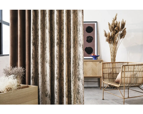 Dekorativní obývací pokoj se závěsy, komodou, dekorací a ratanovým křeslem.