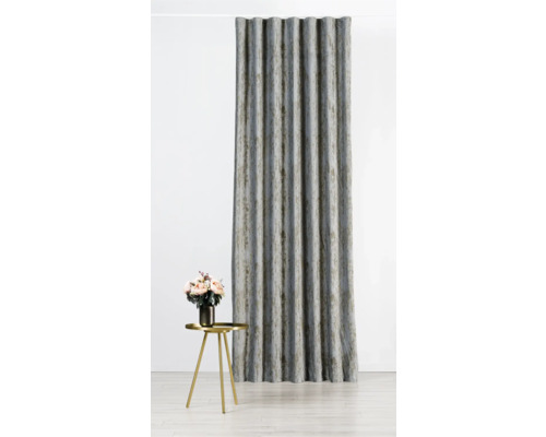 Dekorativní šedý závěs se záhyby vedle zlatého odkládacího stolku s květinovou vazbou