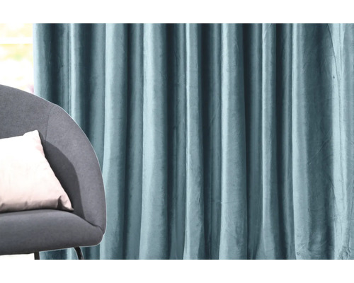 Dekorativní látkový okenní závěs vedle křesla