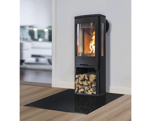 Krbová kamna s prostorem na dřevo a skleněnou podlahovou deskou v obývacím pokoji.