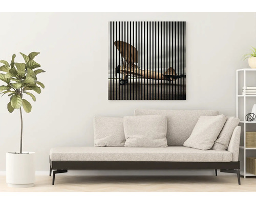 Obývací pokoj s pohovkou a nástěnným obrazem s motivem letadla