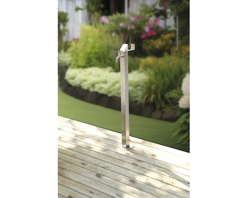 Kovový zahradní výtok na dřevěné terase se zahradou v pozadí