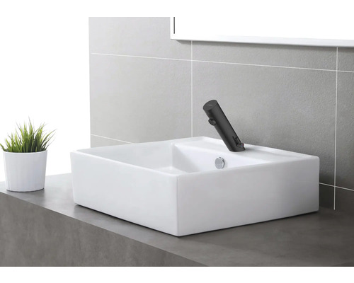 Obdélníkové umyvadlo na desku s baterií v moderní koupelně.