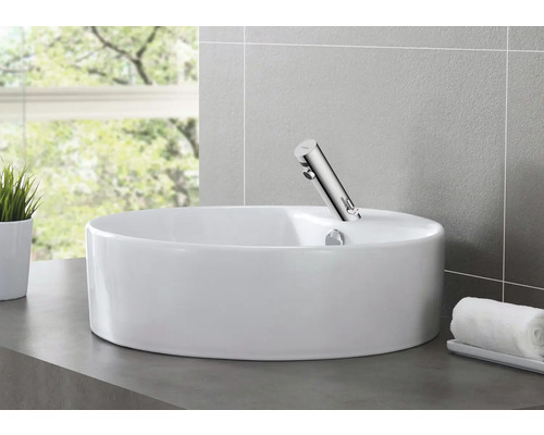 Keramické umyvadlo na desku s baterií v koupelně.