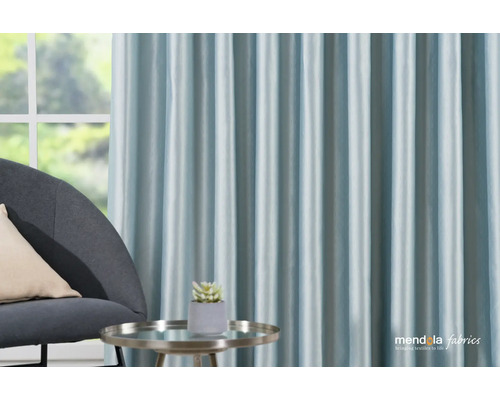 Dekorativní obývací pokoj s modrými závěsy, křeslem a odkládacím stolkem