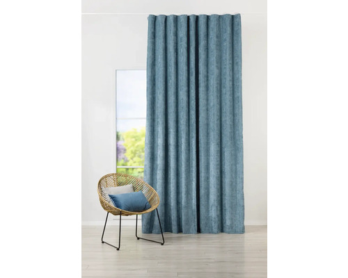 Interiérová fotografie obývacího pokoje s modrým závěsem a ratanovým křeslem