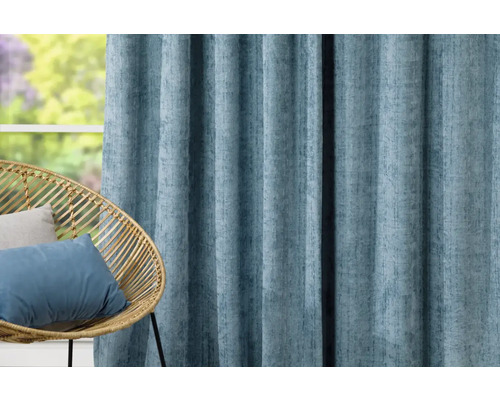 Dekorativní závěs z látky vedle ratanového křesla