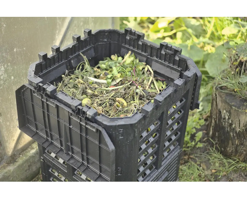 Plastový kompostér s organickým odpadem na zahradě