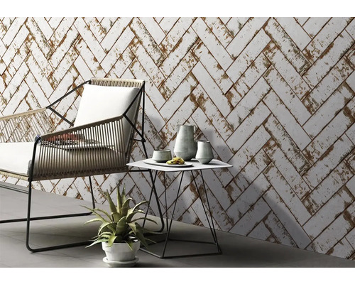 Design obývacího pokoje se stěnou z bílých obkladů ve vzoru rybí kosti, židle a stolu.