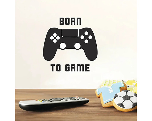 Samolepka na zeď s textem Born to Game a symbolem ovladače, spolu s dálkovým ovladačem a sušenkami