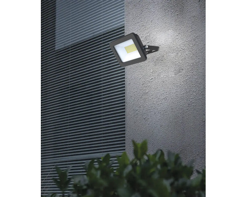 Čtvercový LED venkovní reflektor namontovaný na stěně domu.