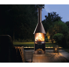 Zahradní scéna s venkovním krbem, dřevem a zahradním nábytkem na terase