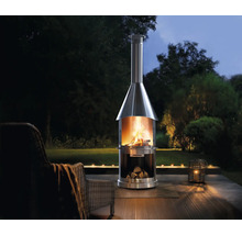 Nerezový venkovní krb s dřevem a ohněm na zahradě