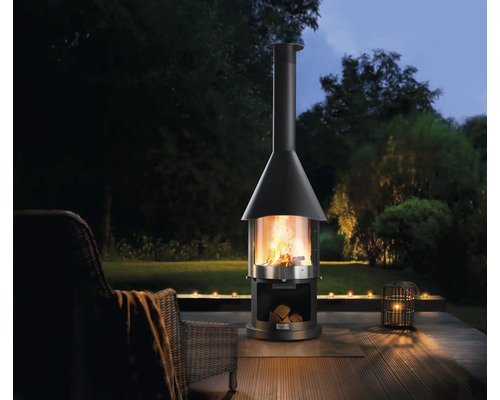 Zahradní scéna s venkovním krbem, poleny a svíčkami