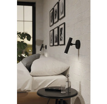 Ložnice s postelí, nočním stolkem a dvěma nástěnnými svítidly