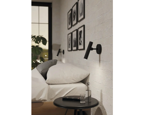 Ložnice s postelí, nočním stolkem a dvěma nástěnnými svítidly