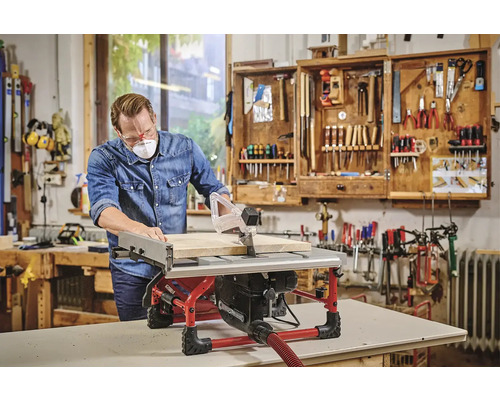 Muž pracuje s kotoučovou pilou v dílně se skříňkou na nářadí