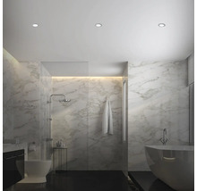 Světlá koupelna se sprchou, vanou, toaletou a mramorovými obklady.