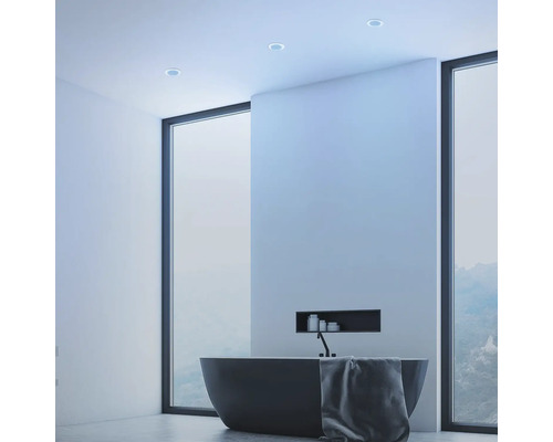 Moderní koupelna s volně stojící vanou, ručníkem a stropními bodovými svítidly.