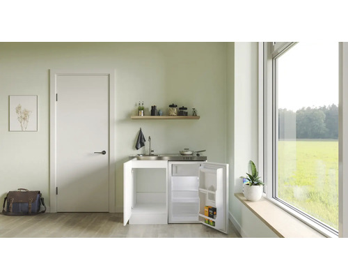 Kompaktní kuchyňská linka s dřezem, varnou deskou a chladničkou ve světlé místnosti