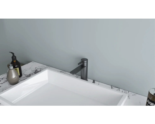 Moderní koupelna s bílým umyvadlem na desce a černou baterií na mramorové desce