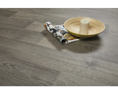 Položená vinylová podlaha s dřevěným dekorem, časopisem, svíčkou a mísou.