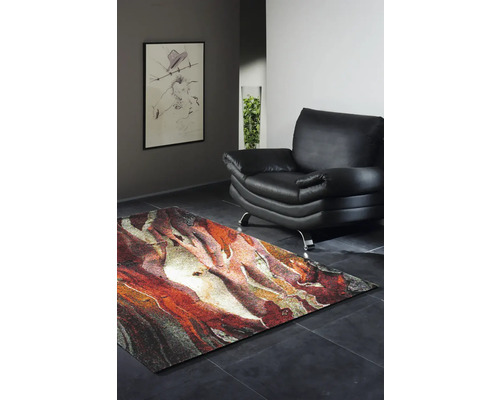 Obývací pokoj s abstraktním kobercem, křeslem a zarámovaným obrazem