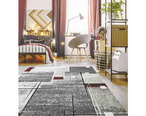 Ložnice s postelí, psacím stolem a šedým kobercem s geometrickým vzorem