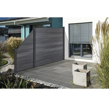 Dřevěný plot v zahradní oblasti s rostlinami a dlažebními kostkami