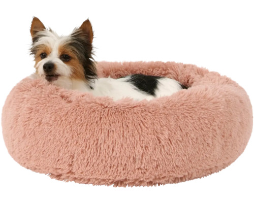 Pes leží v kulaté, chlupaté posteli pro domácí mazlíčky.