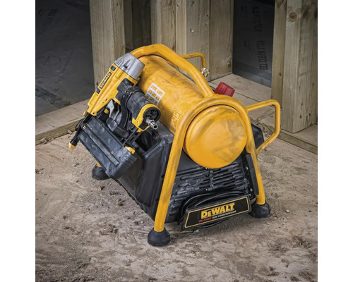 Žlutý vzduchový kompresor DeWalt s pneumatickou hřebíkovačkou na staveništi