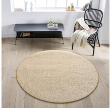 Béžový kulatý koberec v obývacím pokoji s křeslem a stolem