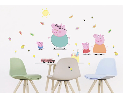 Nástěnná dekorace s motivy Prasátka Peppy v dětském pokoji nad stolem a židlemi.