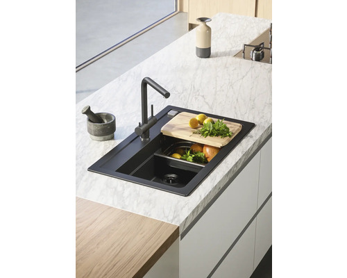 Černý kuchyňský dřez s baterií a příslušenstvím na mramorové desce