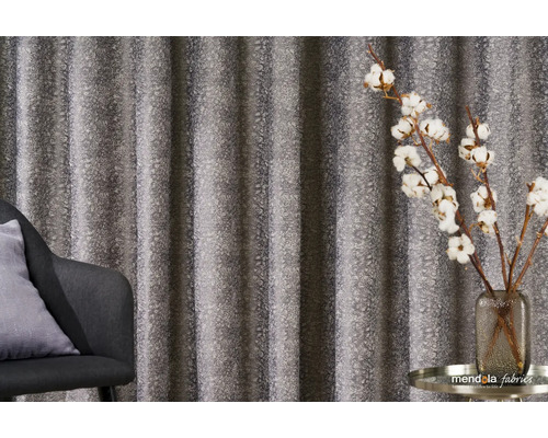 Dekorativní závěs se vzorem vedle křesla a vázy