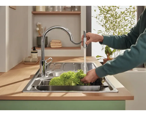 Nerezový dřez s jednopákovou baterií a sprchovou hadicí při mytí zeleniny
