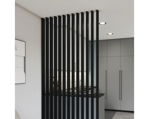 Dělič pokoje z černých dřevěných lamel v moderně zařízeném pokoji