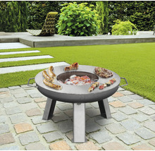 Nerezový grilovací stůl s klobásami, steaky a špízy na zahradě