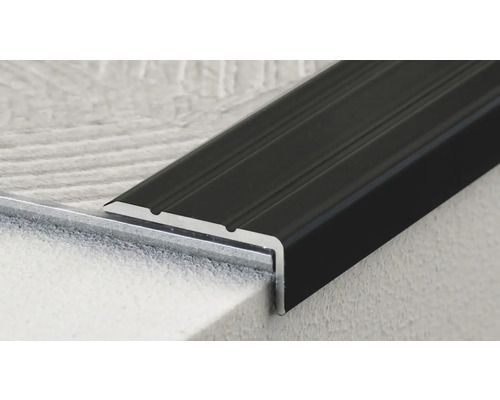 Detailní záběr černého kovového schodišťového profilu.