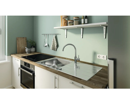 Kuchyňská scéna s umyvadlem, varnou deskou a kuchyňským náčiním na zdi