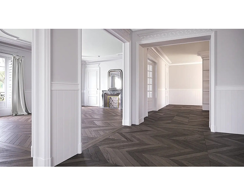 Světlý pokoj s parketami do rybí kosti, bílými stěnami a štukovými ozdobami