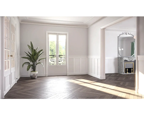 Světlá místnost s parketami do stromečku, okny s mřížemi a pokojovou rostlinou v květináči