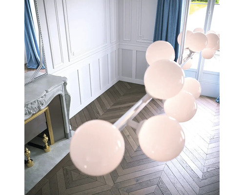 Obývací pokoj s krbem, parketami ve tvaru rybí kosti a moderním molekulovým stropním svítidlem.