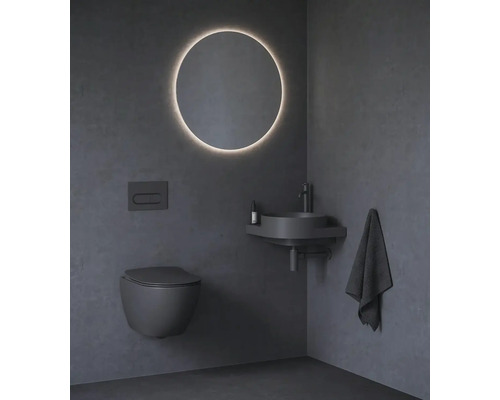 Moderní koupelna s toaletou, umyvadlem, zrcadlem a ručníkem