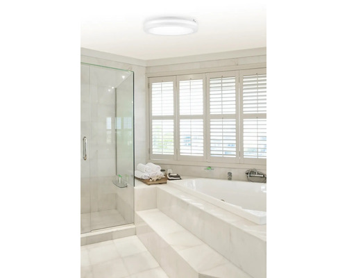 Světlá koupelna se sprchou, vanou a kulatým stropním svítidlem