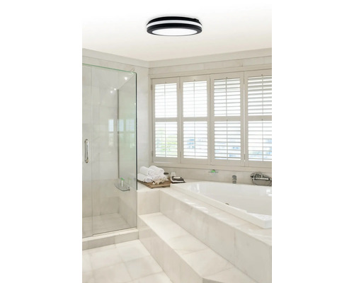 Koupelna se sprchou, vanou, oknem a kulatým stropním svítidlem