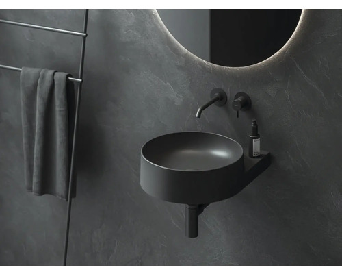 Moderní koupelna s kulatým zrcadlem, umyvadlem a držákem na ručníky