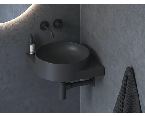 Moderní koupelna s kulatým umyvadlem na desku, baterií a ručníkem